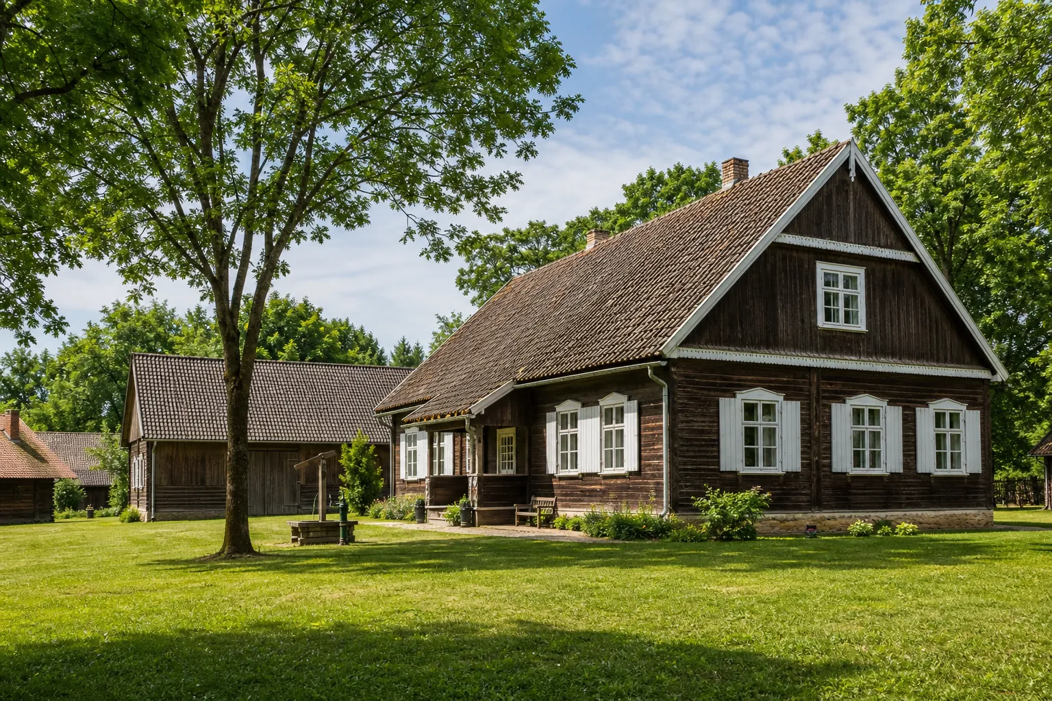 Agluonėnų etnografinės sodybos medinis lietuvininkų namas su tvarkingu kiemu ir ūkiniais pastatais