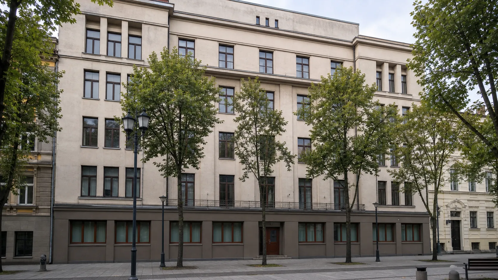 Ateitininkų sąjungos rūmų Kaune šviesus penkių aukštų fasadas Laisvės alėjoje su stačiakampiais langais, sekliais rizalitais ir medžiais