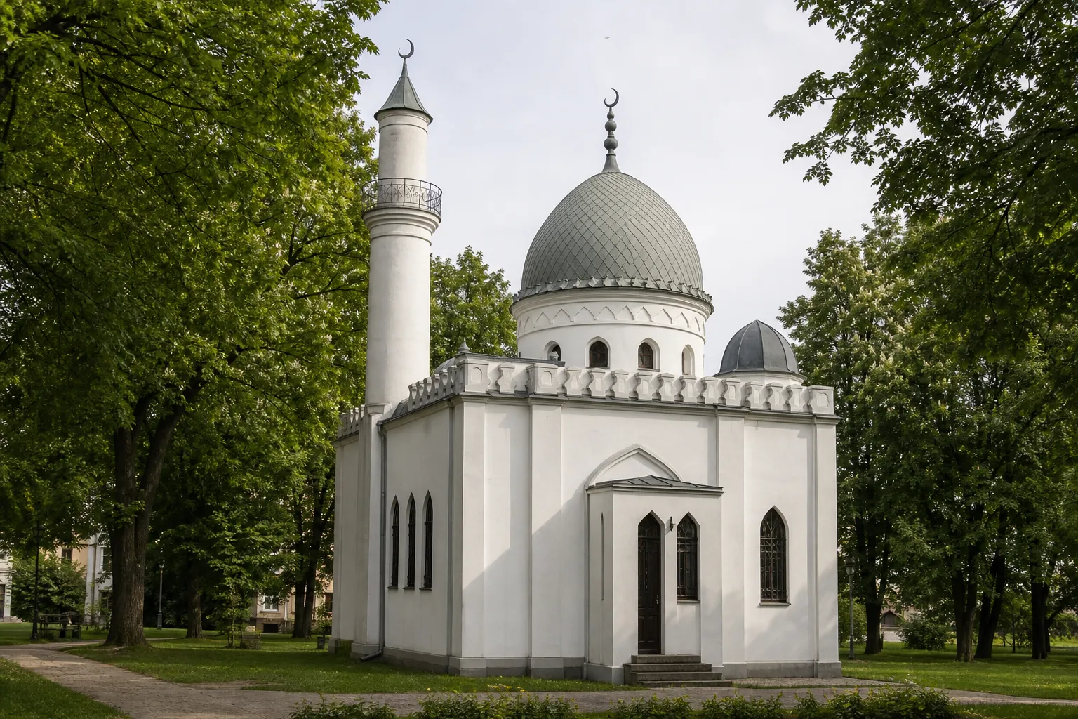 Balta Kauno totorių mečetė Ramybės parke su centriniu kupolu, vienu minaretu, arkiniais langais ir medžių apsuptu fasadu