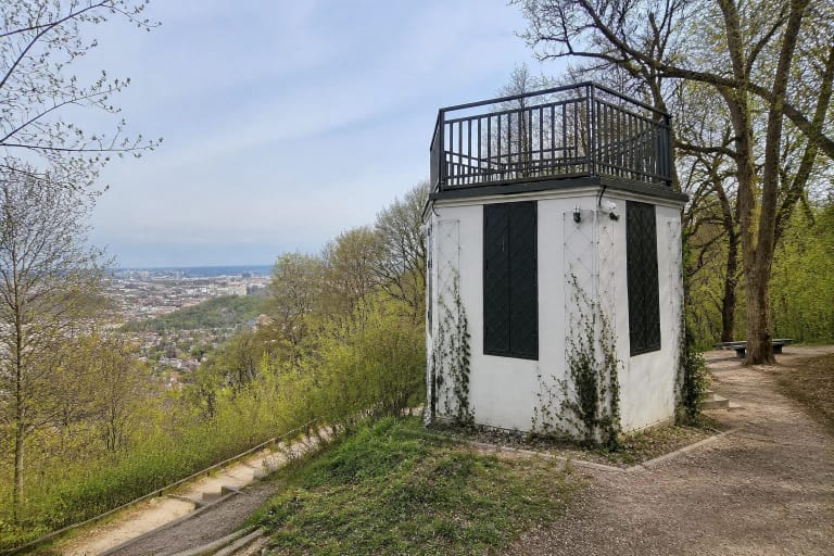 Baltas aštuoniakampis Altanos bokštelis miškingame Vilniaus Kalnų parko šlaite