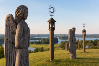 Grassy Angel Hill in Trakai with wooden angel sculptures and the Trakai lakes landscape