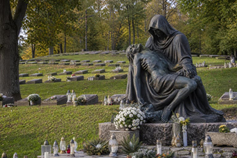 Antakalnio kapinių Laisvės gynėjų memorialo Pietos skulptūra tarp žvakių ir kapų