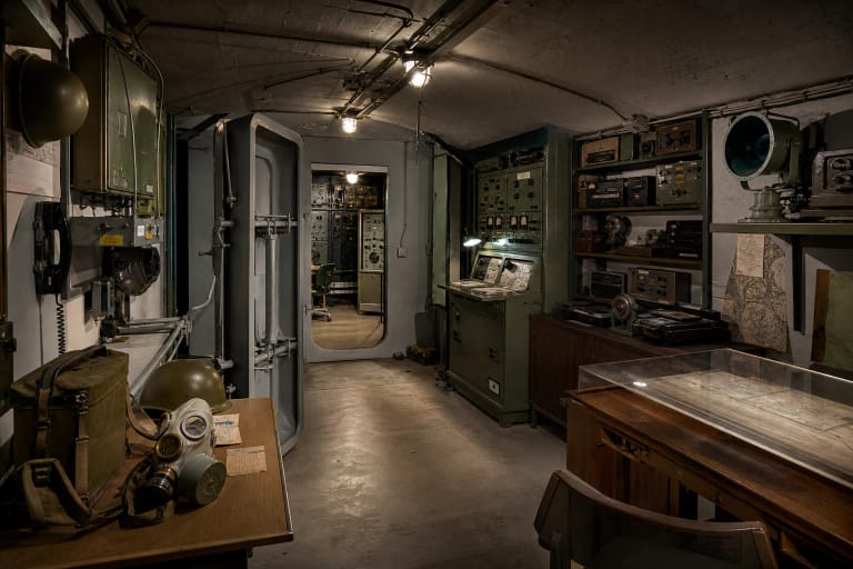 Atomic Bunker exhibition in Kaunas with KGB communication and surveillance equipment, civil defence signs, and metal doors