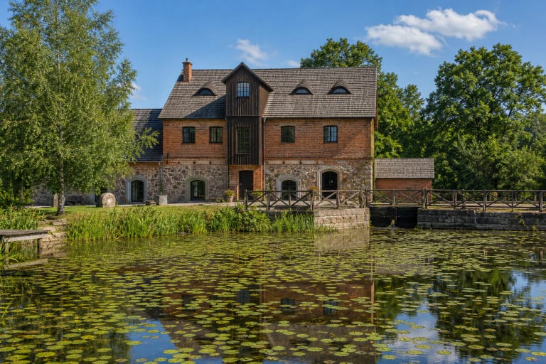 Brick and stone Babrungėnai Watermill by a pond with water lilies