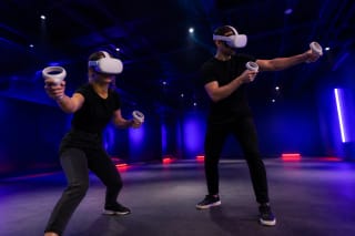 Два игрока в белых VR-шлемах с контроллерами в тёмном сине-фиолетовом пространстве Bala VR