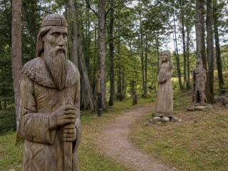 Wooden sculpture on the forest trail at Baltic Mythology Park in Sausdravai