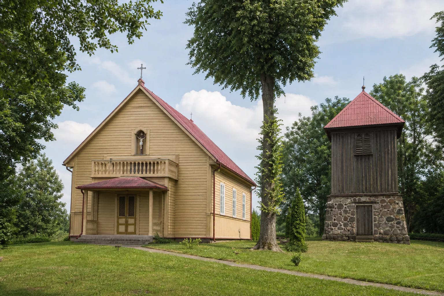 Yellow wooden Butrimonių Church of St Michael with a red roof, trees, and a separate belfry