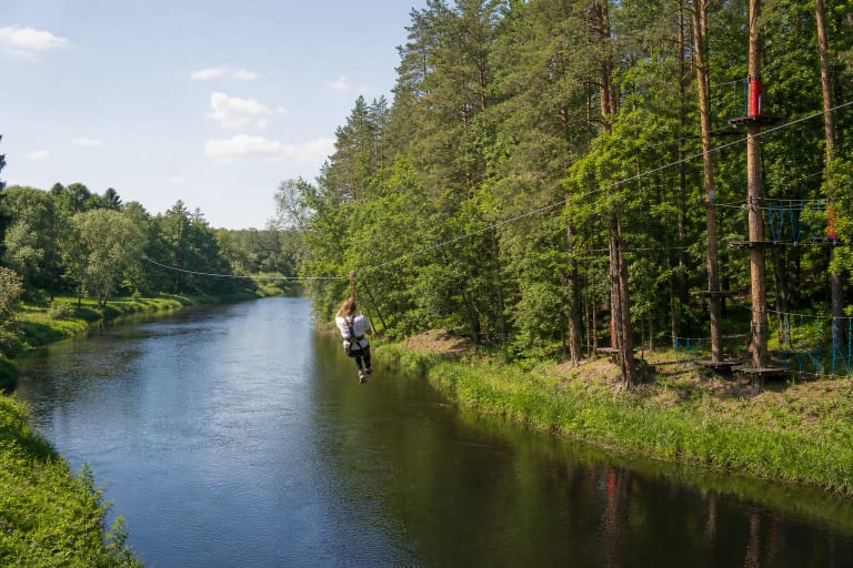 Lynu virš Šventosios skrendanti lankytoja ir Dainuvos nuotykių slėnio trasos Anykščių šilelyje