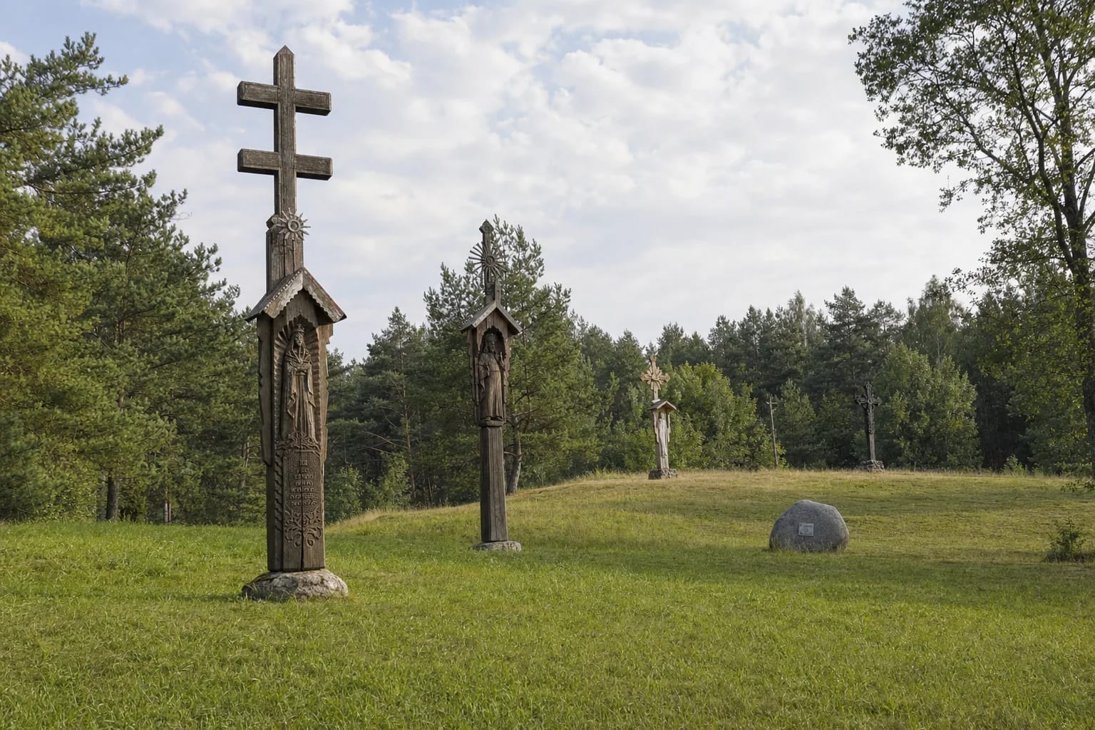 Wooden crosses on a grassy pine-covered slope in Didžiosios Kovos Partisan District Memorial Park