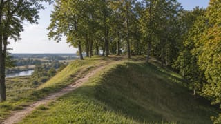 Dovilai Hillfort above the Minija valley with wooded slopes