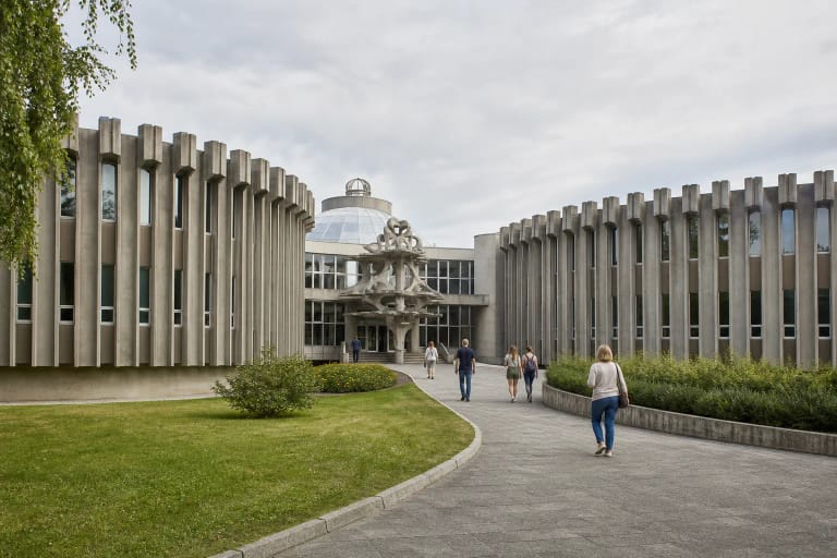 Druskininkų vandens parko simetriški pilko betono korpusai, centrinis stiklinis vestibiulis, kupolas ir skulptūra prie įėjimo
