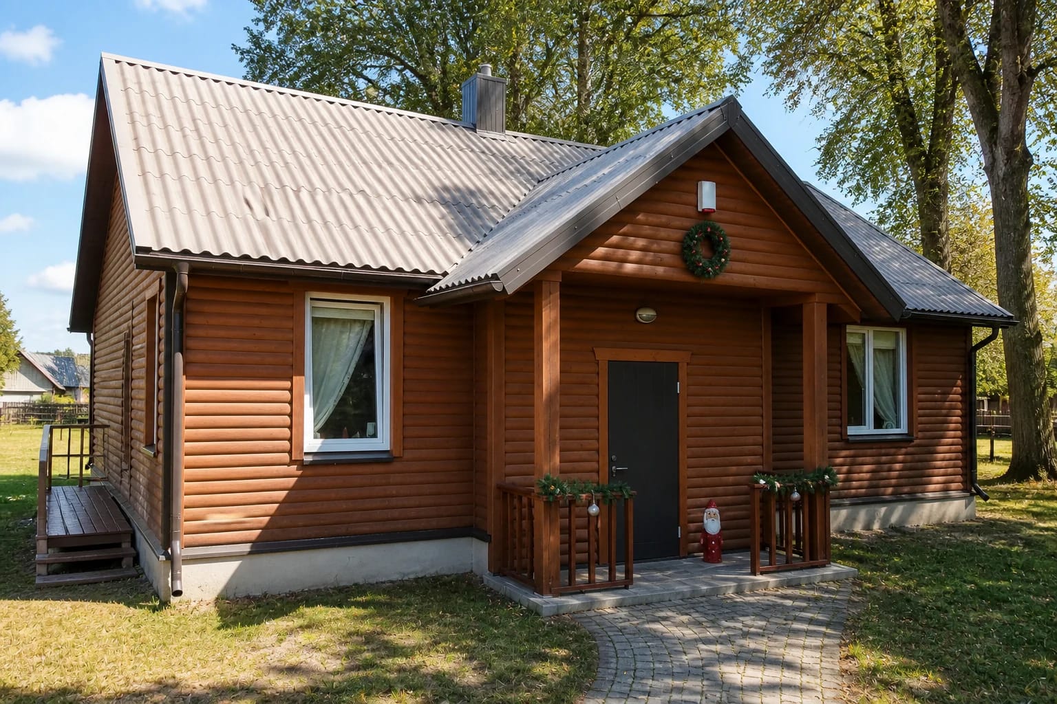 The wooden Christmas Tree Ornaments Museum in Miežiškiai with a white gabled roof and mature trees
