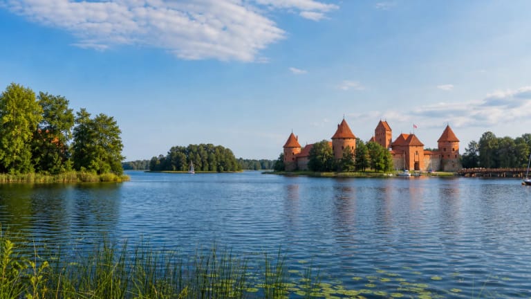 Galvės ežero salos su Trakų salos pilimi, mėlynu vandeniu ir žaliais Trakų krantais