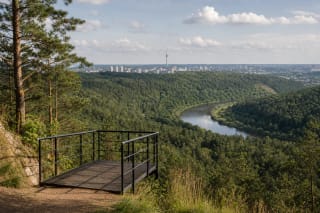 Gariūnų regyklos metalinė platforma virš miškingo Neries slėnio su TV bokštu horizonte