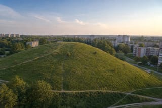 Green Ieva Simonaitytė Hill among the apartment blocks of southern Klaipėda on a summer evening
