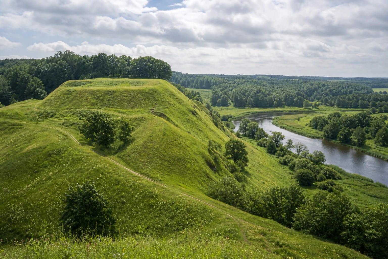 Green hill of Imbarė Hillfort above the confluence of the Salantas and Pilsupis in Samogitia