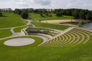 The curved amphitheatre, circular stage and pond in the green terrain of Joninės Valley in Jonava