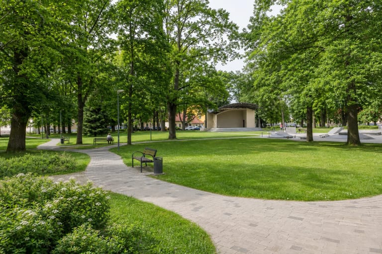 Žalias Joniškio miesto parkas su vingiuojančiu taku, vasaros estrada ir jaunimo laisvalaikio erdve