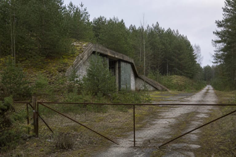 Pušyne nykstantis buvusios Josvainių raketų bazės betoninis angaras ir sutrūkinėjęs kelias