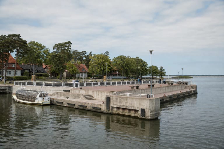 Juodkrantės keleivinių laivų prieplauka su betoninėmis krantinėmis, šviesiais turėklais ir ramia Kuršių marių panorama