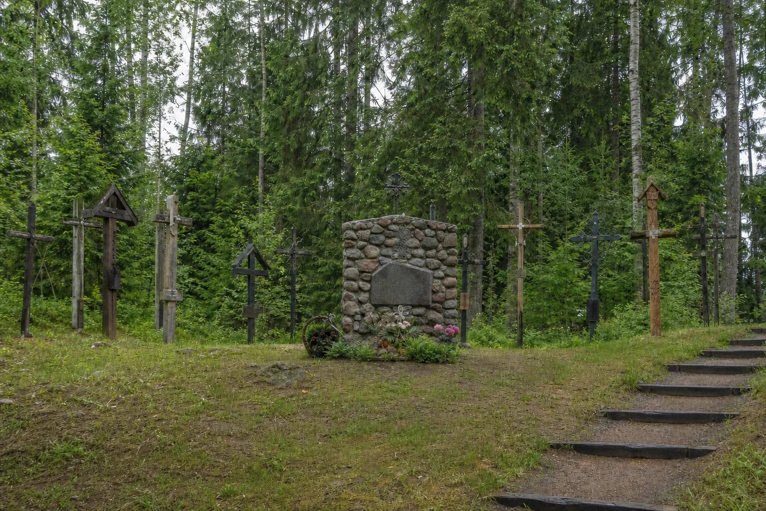 Fieldstone monument and varied wooden and metal crosses at the Battle of Kalniškė site on wooded Meškakalnis hill