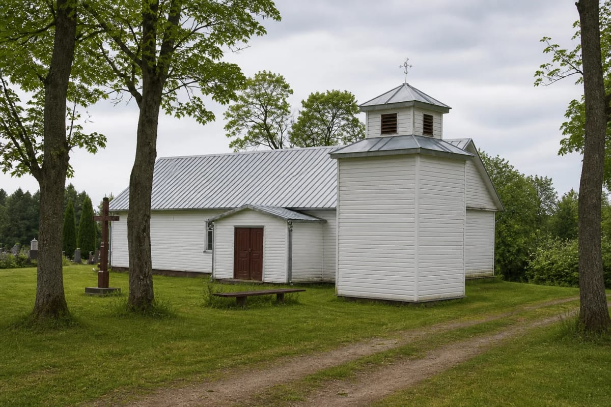 White wooden Kalnujai Church of St Victor with a small bell turret among trees