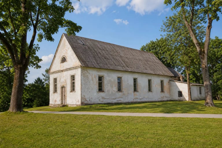 Bokštų netekusi balta Kalvarijos evangelikų liuteronų bažnyčia su ilgu tinkuotu fasadu ir tamsiu dvišlaičiu stogu