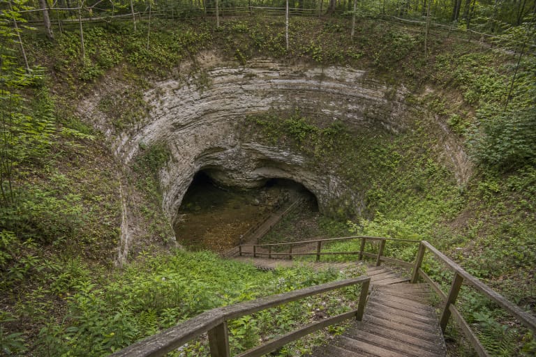 Karvės olos karstinė smegduobė su dolomito sienomis ir mediniais laiptais Biržų regioniniame parke