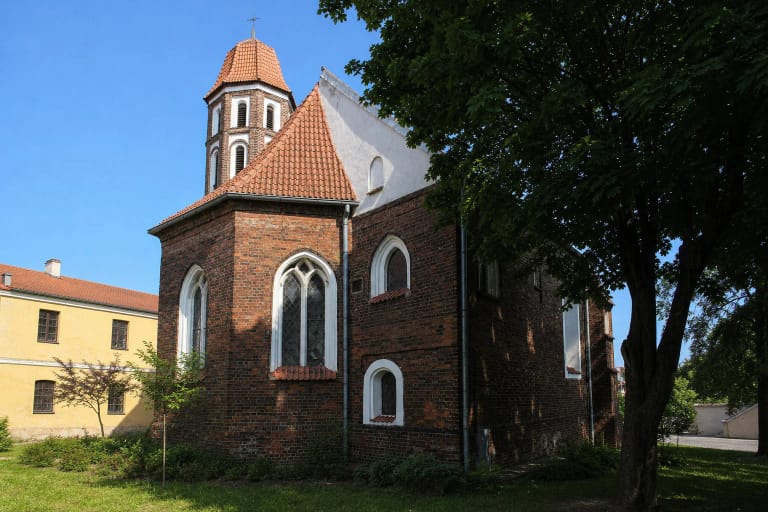 Raudonų plytų gotikinė Kauno Šv. Mikalojaus bažnyčia su aštuonkampiu bokšteliu benediktinių kieme
