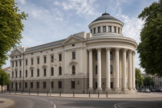 Light facade of Kaunas State Philharmonic with semicircular column portico, rusticated base, and small domed tower