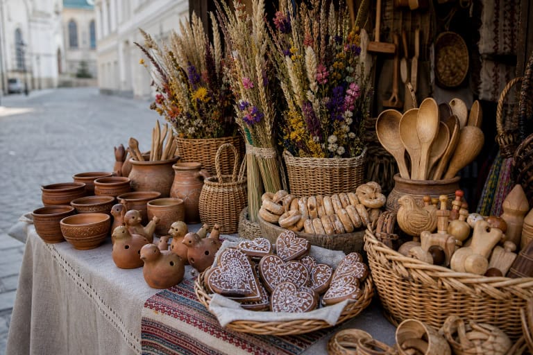 A Kaziukas Fair table with Vilnius verbos, pottery, wickerwork, wooden spoons, bagels, and gingerbread