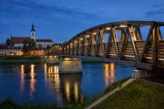 Kėdainiai pedestrian bridge over the Nevėžis at blue hour with the historic riverbank beyond