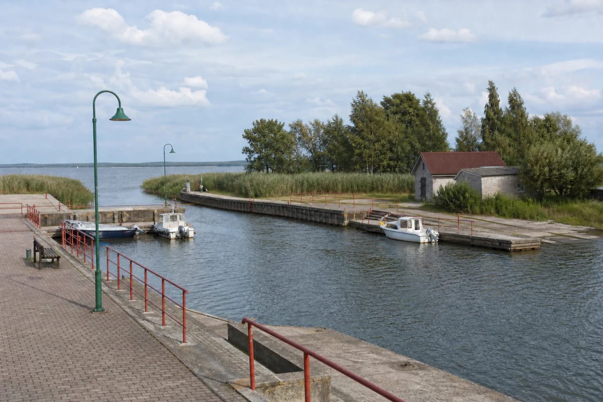 Kintai Harbour's small-craft basin with a two-level quay, red safety rails, boats, and a reed-fringed shore