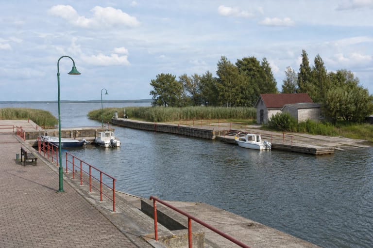 Kintų uosto mažųjų laivų baseinas su dviejų lygių krantine, raudonais turėklais, valtimis ir nendrynų pakraščiu