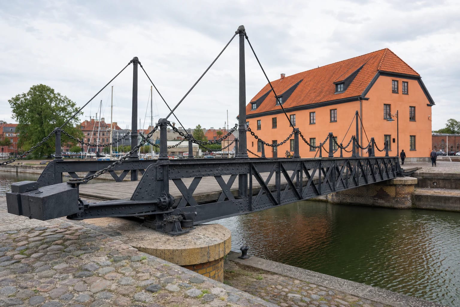 Closed Klaipėda Swing Bridge with riveted iron trusses, chain railings, and an oak deck over the Castle Harbour channel