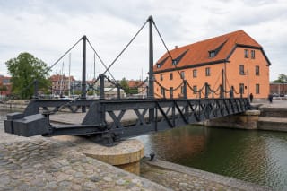 Closed Klaipėda Swing Bridge with riveted iron trusses, chain railings, and an oak deck over the Castle Harbour channel