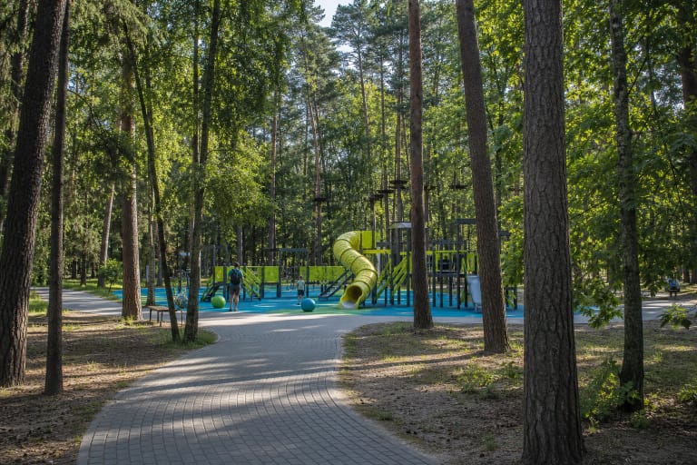 Klaipėdos poilsio parko pušynas, vingiuotas takas ir mėlynai žalia vaikų žaidimų aikštelė