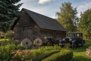 Piniavos sodybos muziejaus medinė klėtis su girnapusėmis, senovine žemės ūkio technika ir 1931 metų automobiliu