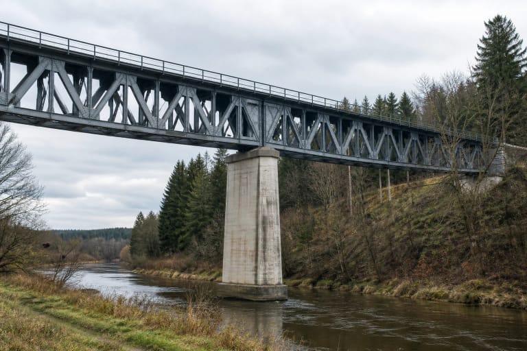 Riveted steel truss and tall concrete pier of Kūlupėnų Railway Bridge above the Salantas valley
