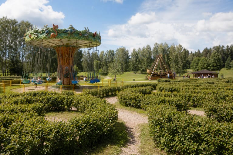 LABI parko gyvatvorių labirintas, grandininė karuselė ir piratų laivo atrakcionas žaliame Anykščių kraštovaizdyje