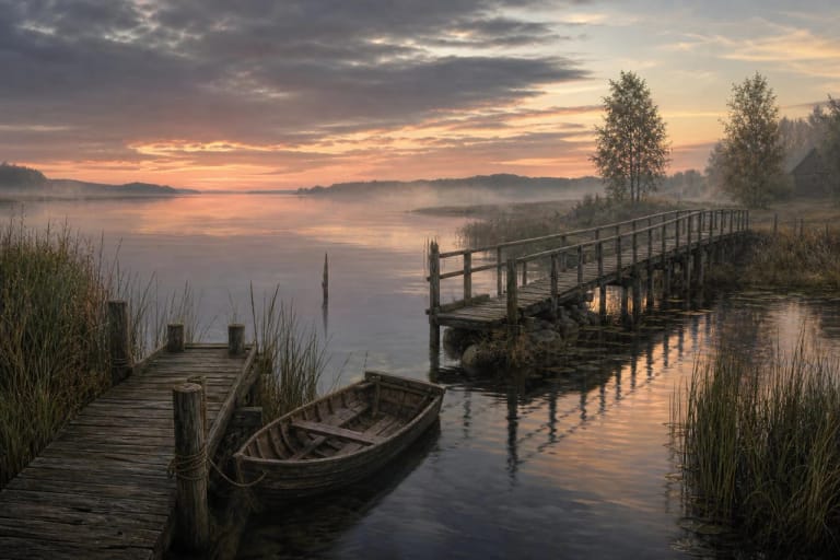 A wooden boat beside a sea and bridge as a Lithuanian folklore symbol of journey and boundary