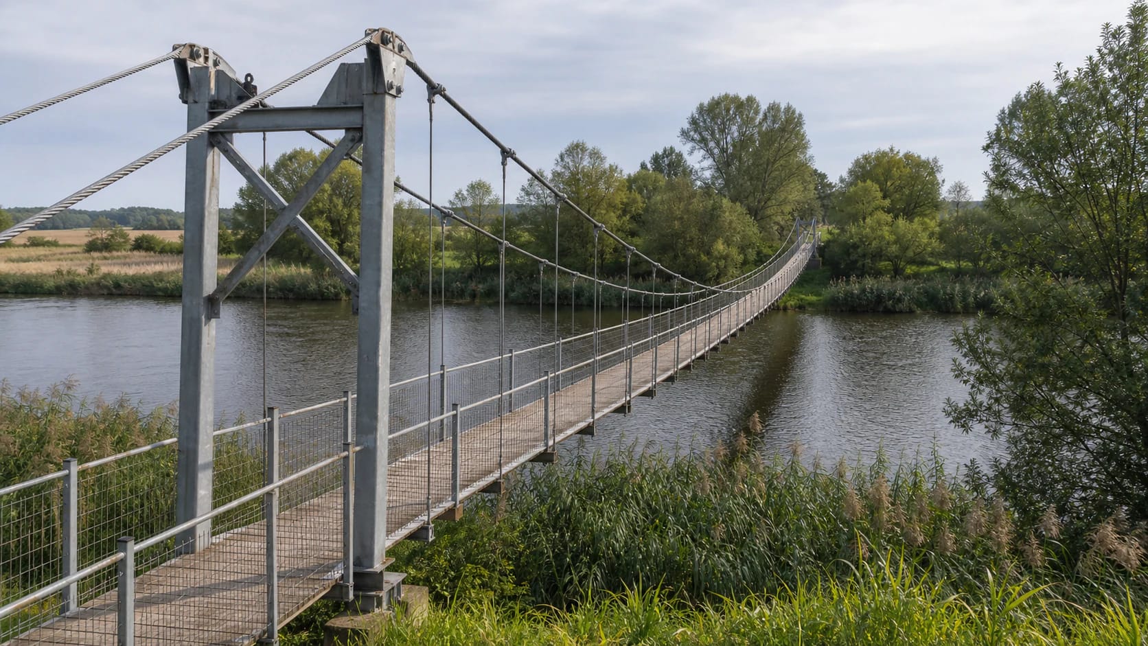Lankupiai Suspension Bridge across the Minija with metal cables and wooden planks