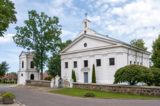 White classical facade and detached belfry of the Church of the Assumption of the Blessed Virgin Mary in Leipalingis