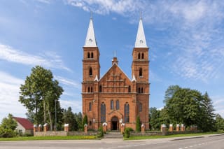 Leliūnų Šv. Juozapo bažnyčios raudonų plytų fasadas su dviem šviesiais bokštais
