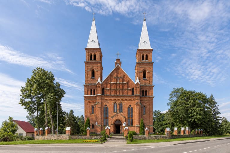 Leliūnų Šv. Juozapo bažnyčios raudonų plytų fasadas su dviem šviesiais bokštais