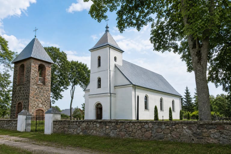 St Anne's Church in Lenkimai with a stone bell tower and churchyard fence