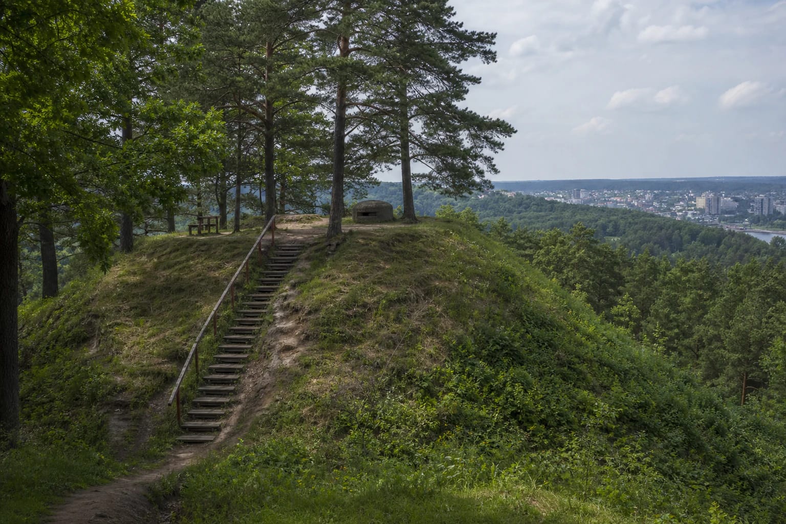 Lentainių piliakalnio mediniai laiptai, pušys, betoninis bunkeris ir Kauno panorama