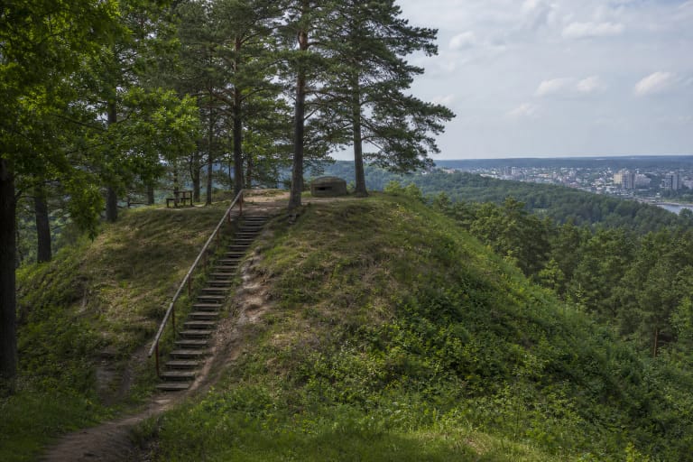 Lentainių piliakalnio mediniai laiptai, pušys, betoninis bunkeris ir Kauno panorama