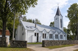 Liudvinavo Šv. Liudviko bažnyčia su baltais fasadais, pilku stogu, bokštais ir akmenine šventoriaus tvora