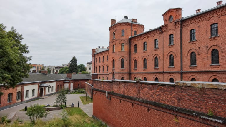 Lukiškių kalėjimo 2.0 raudonų plytų fasadas ir uždaras istorinio kalėjimo kiemas Vilniuje